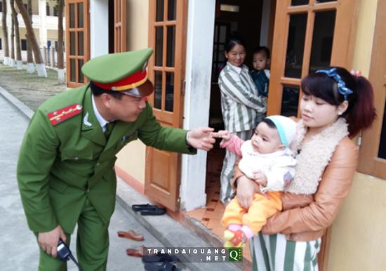 Đại úy Đinh Trọng Tuấn mừng tuổi con phạm nhân trong dịp Tết Ất Mùi. 